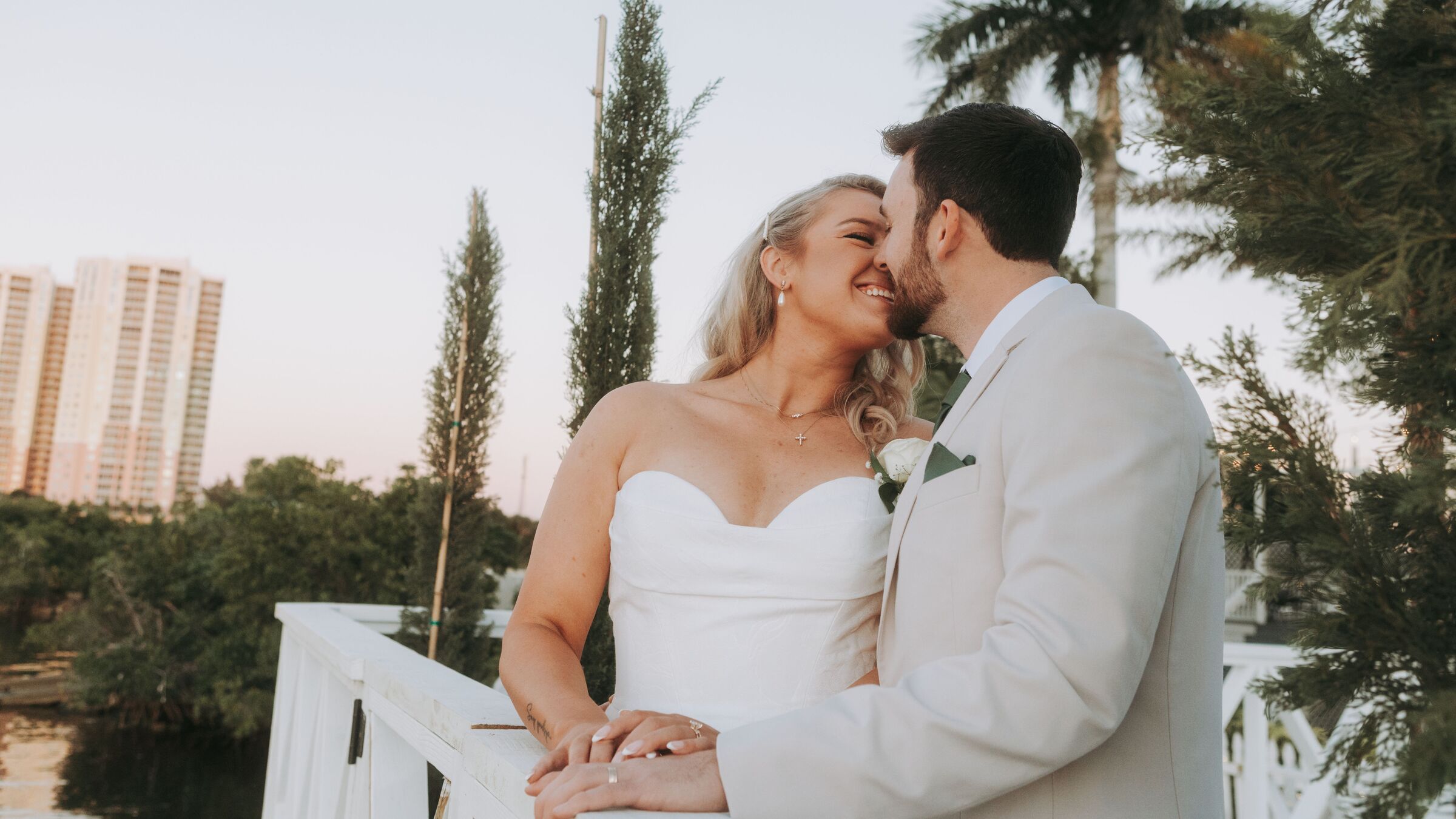 A bride and groom kissing at sunset